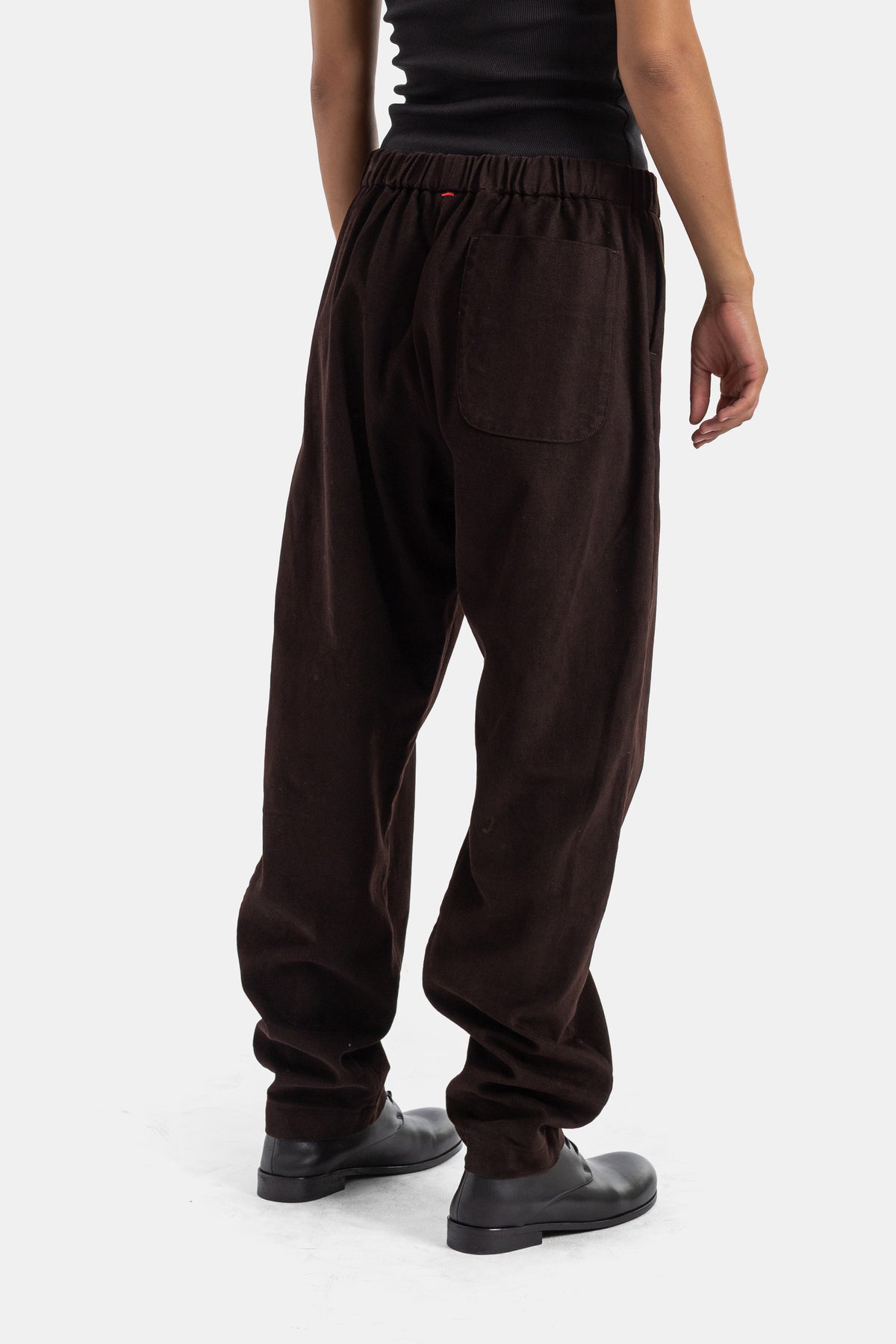 Back view of Casey Casey Jog Ah brown corduroy trousers, patch pocket and red elastic waistband details.
