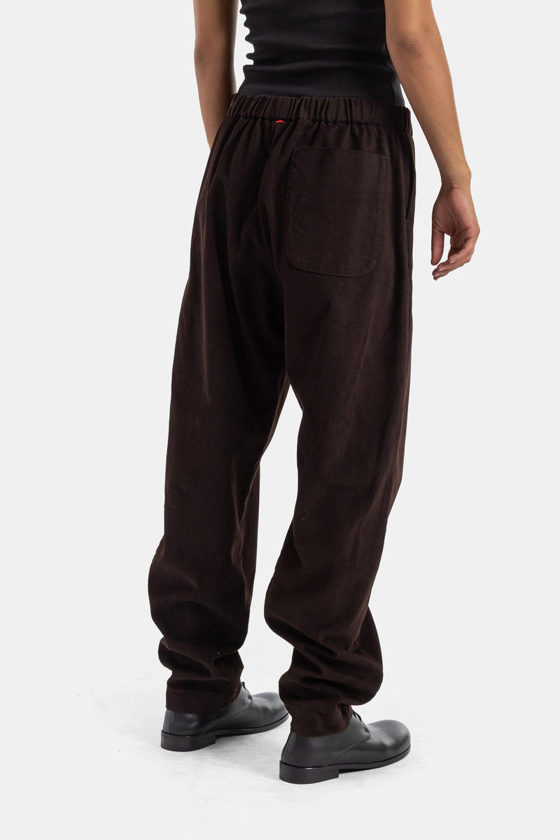 Back view of Casey Casey Jog Ah brown corduroy trousers, patch pocket and red elastic waistband details.
