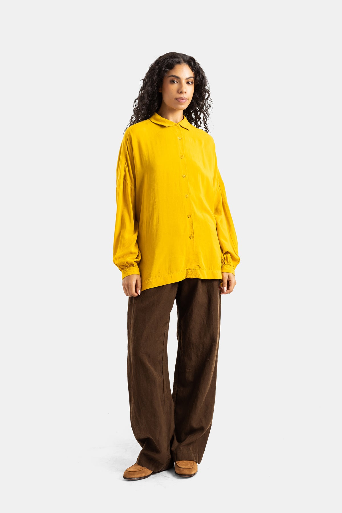Camicia Squarbi Casey Casey donna giallo senape abbinata a pantaloni larghi marroni con bottoni e polsini stretti