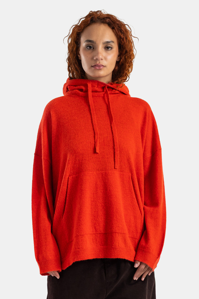 Oversized Casey Casey hoodie in vibrant orange-red bouclé knit, with drawstring hood and kangaroo pocket.