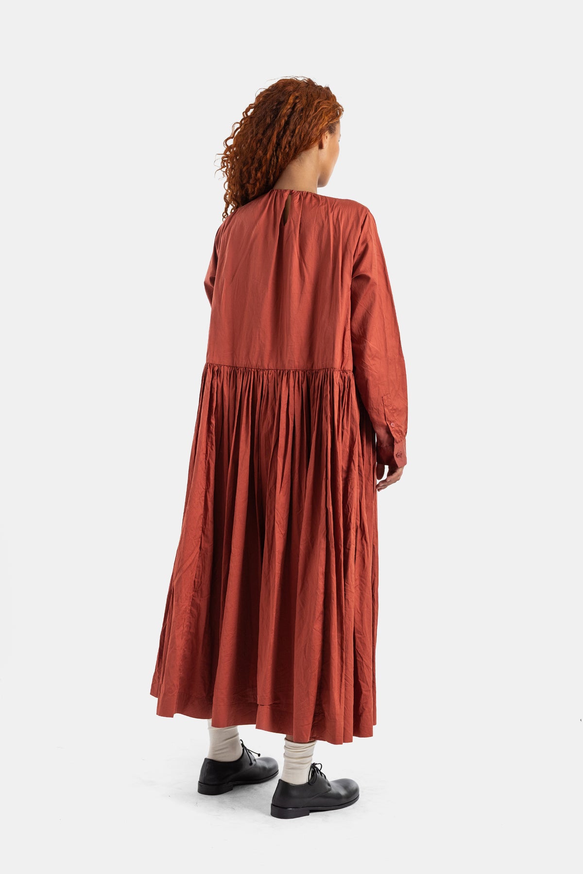 Vestido Pomme Rouche de Casey Casey por detrás con frunces, talle bajo, algodón ladrillo y modelo de pelo pelirrojo.