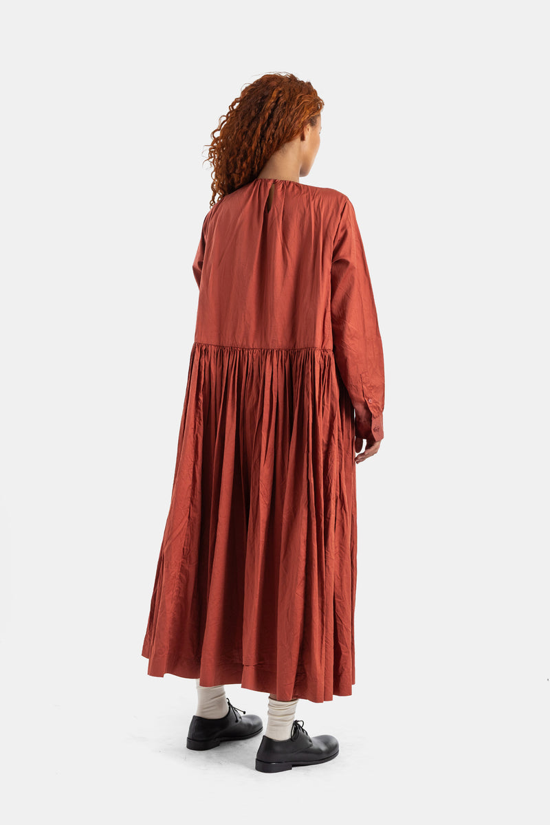 Vestido Pomme Rouche de Casey Casey por detrás con frunces, talle bajo, algodón ladrillo y modelo de pelo pelirrojo.