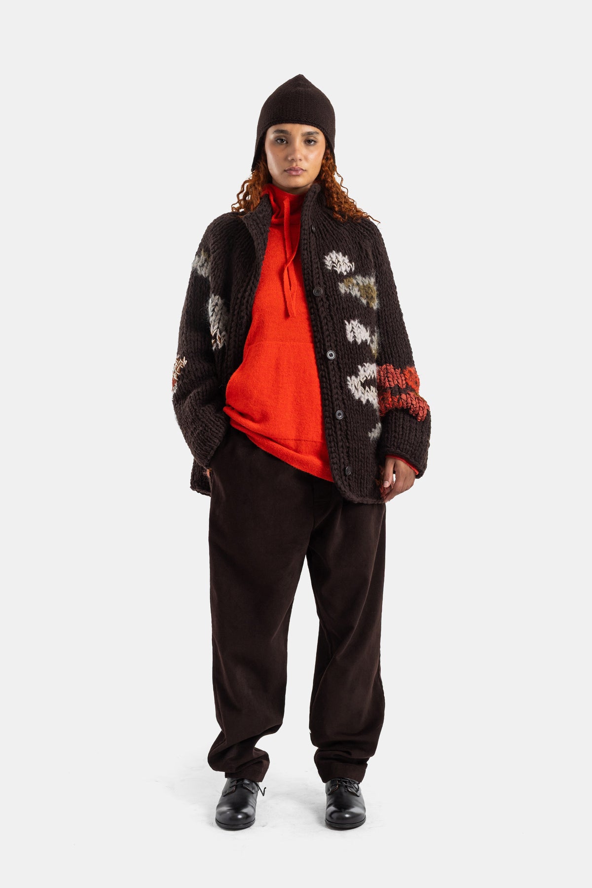 Casey Casey cardigan Flora porté en tenue layering avec pull rouge et bonnet chocolat, silhouette oversize