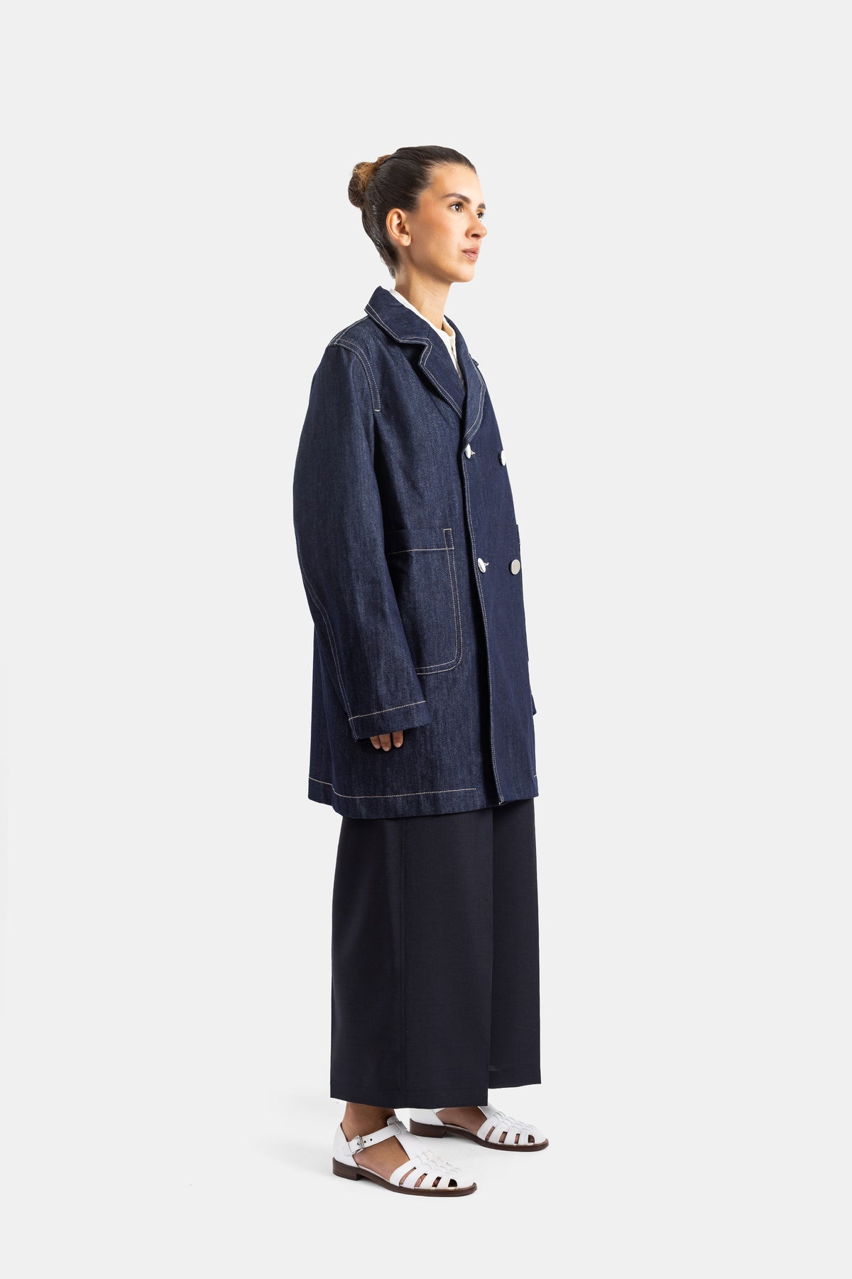 Sofie d'Hoore veste denim marine vue profil silhouette longue avec sandales blanches et jupe large noire