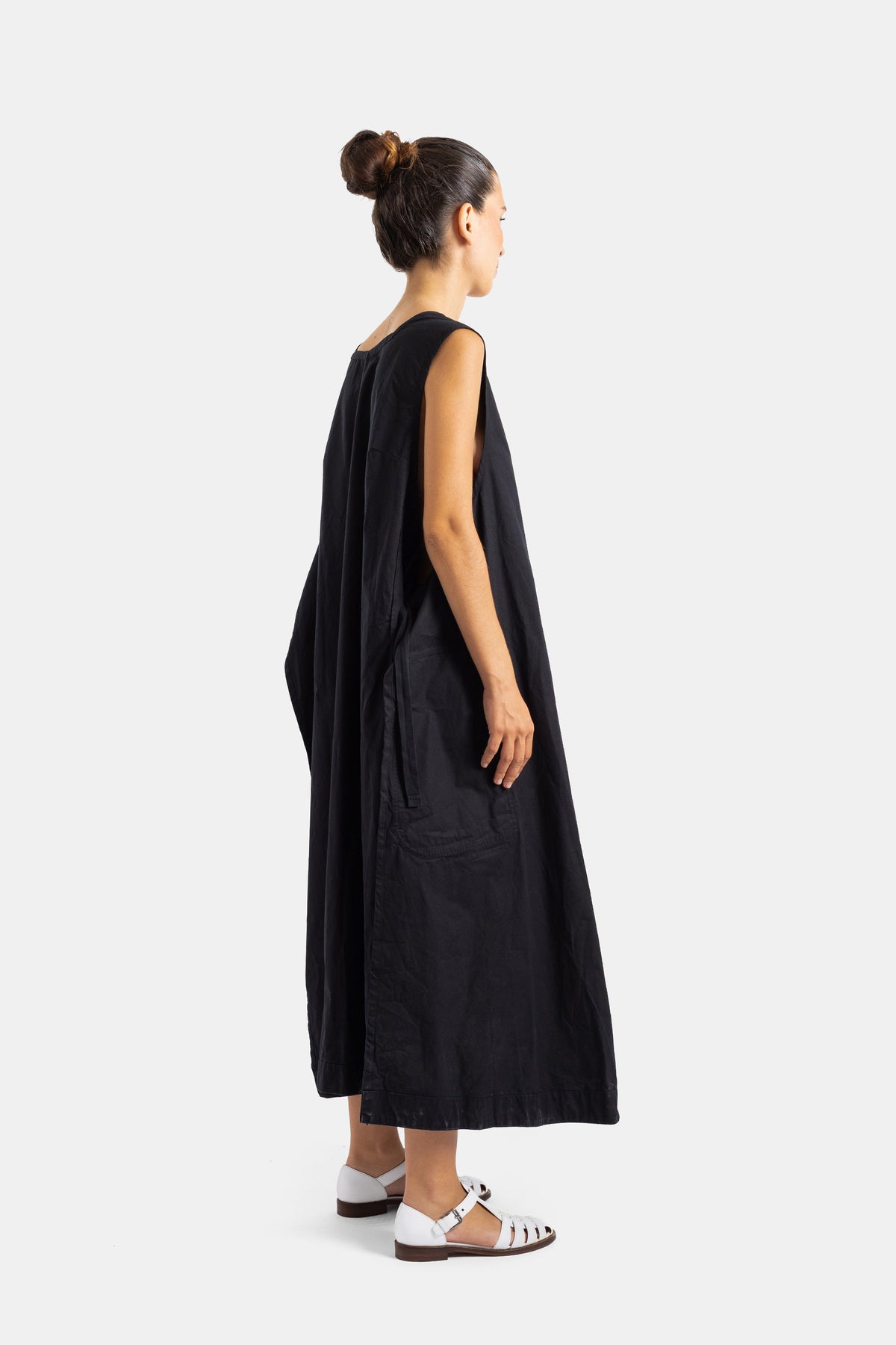 Casey Casey robe tablier longue noire coton froissé vue trois quarts dos, tombé ample fluide et chignon