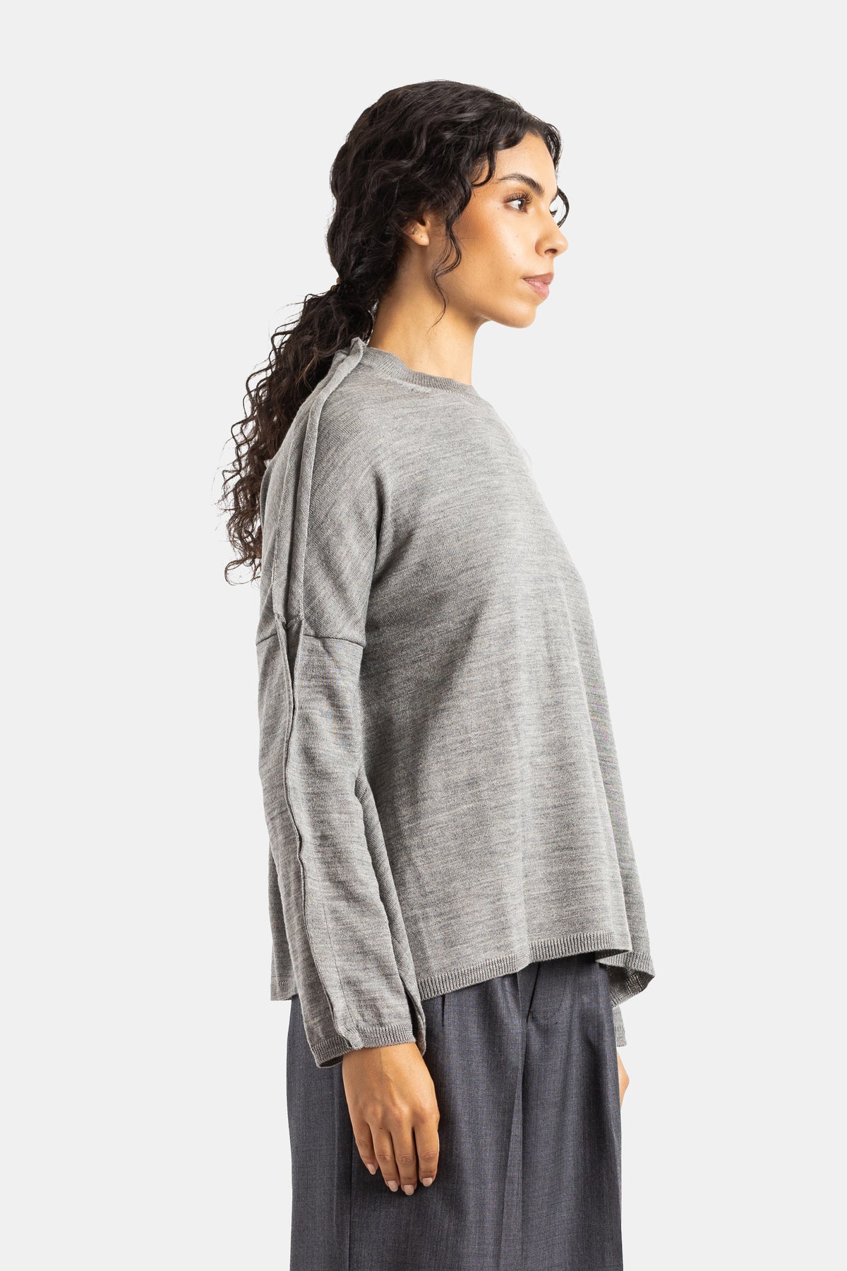 Jersey de lana gris Comme des Garçons de perfil con corte trapecio acampanado y costuras contrastadas mujer