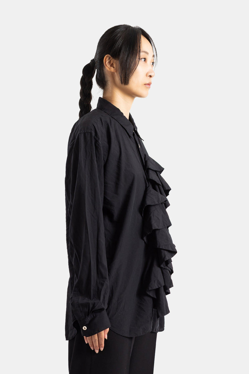 Comme des Garçons chemise noire vue de profil, volants en cascade sur le devant, coupe oversize en coton