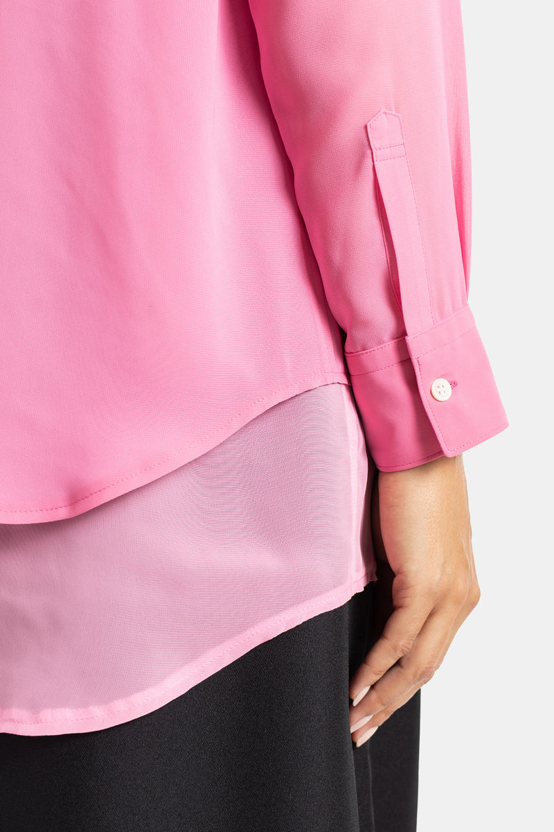 Comme des Garçons détail poignet chemise rose bouton nacré double épaisseur chiffon translucide sur pantalon noir