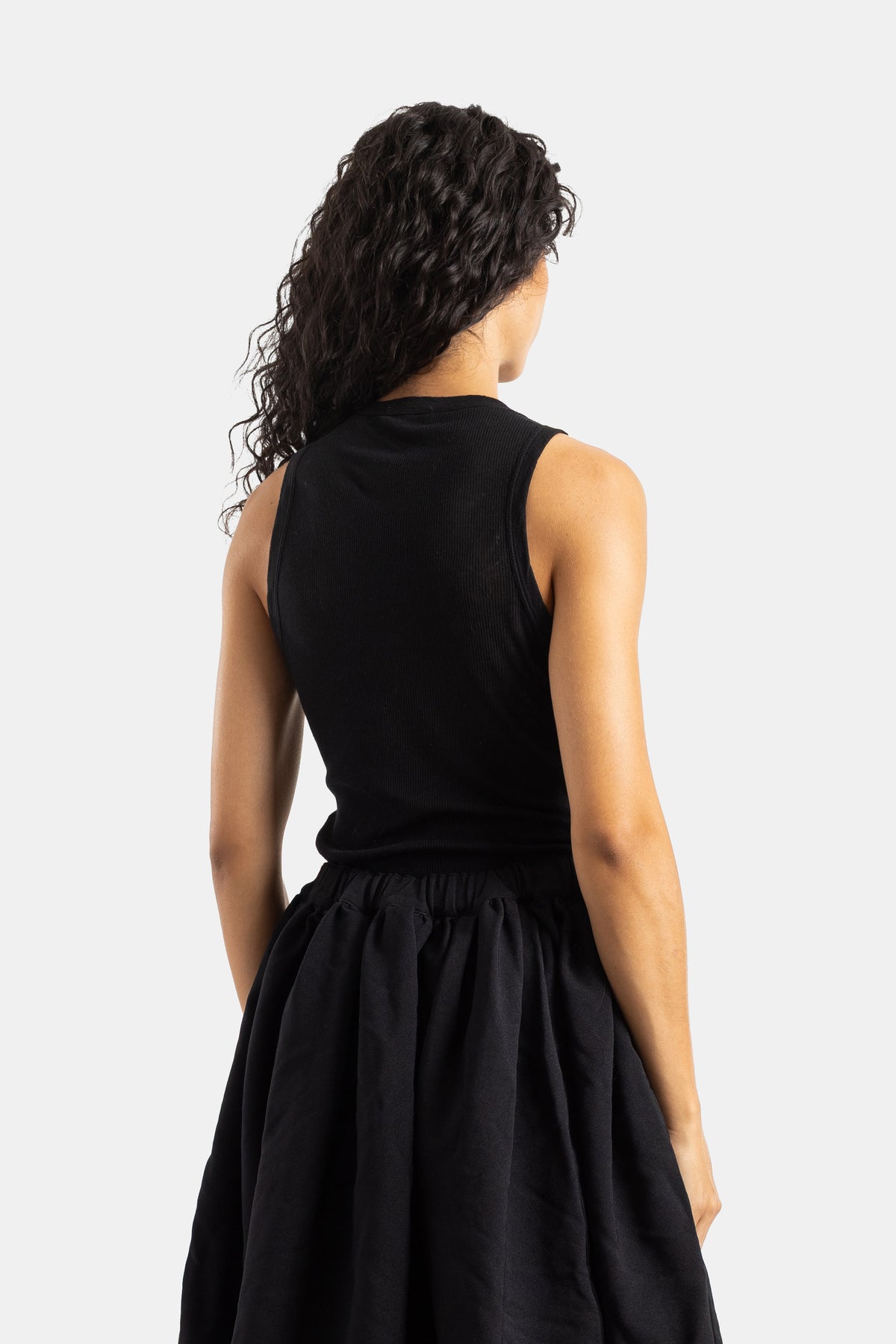 Top sin mangas negro acanalado con espalda descubierta Comme des Garçons de espalda y falda evasé de mujer