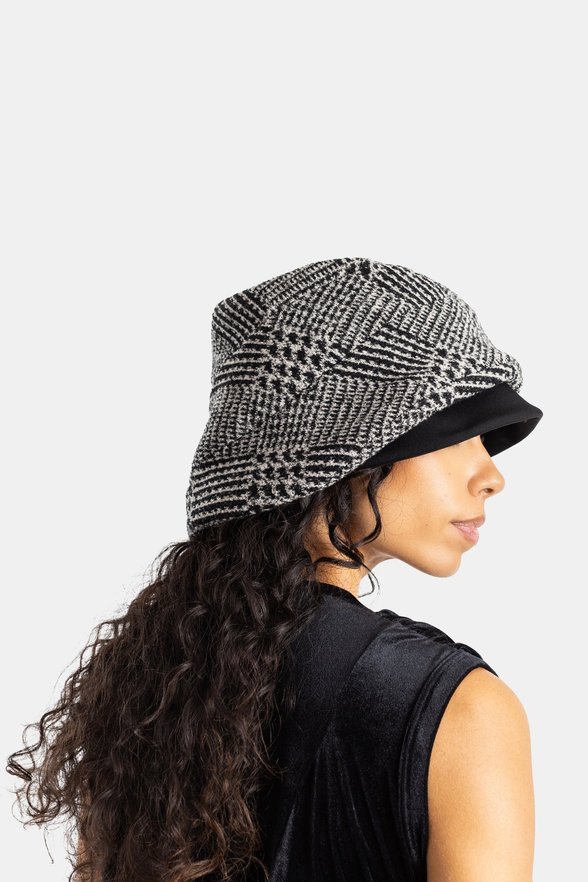 Sombrero de pescador en tweed blanco y negro Comme des Garçons con top de terciopelo sin mangas de mujer
