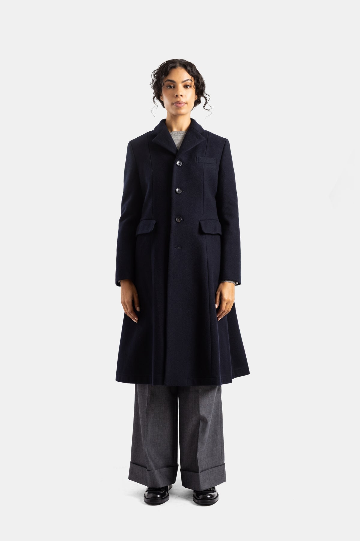 Abrigo largo acampanado Comme des Garçons para mujer en lana azul marino con solapa muescada y corte saco.