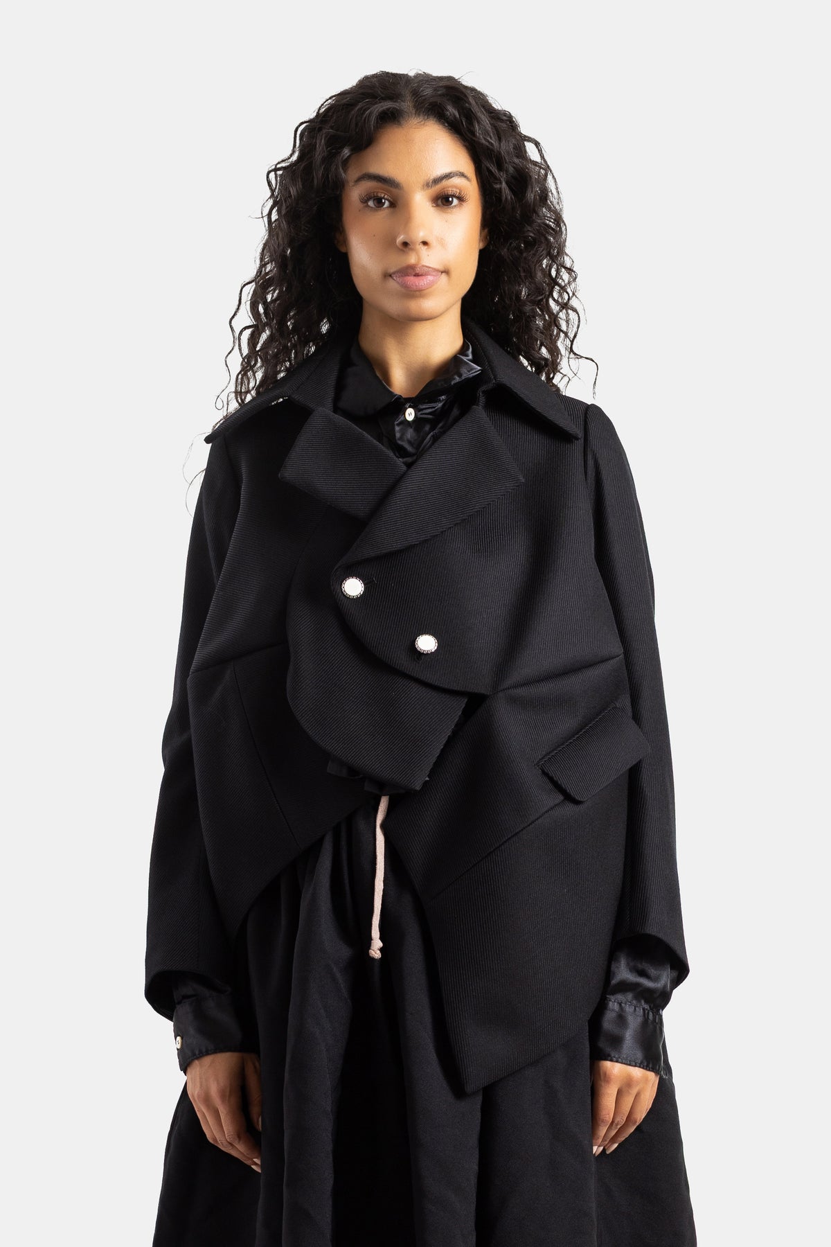 Chaqueta corta asimétrica desestructurada Comme des Garçons de lana negra con volúmenes y botones nacarados