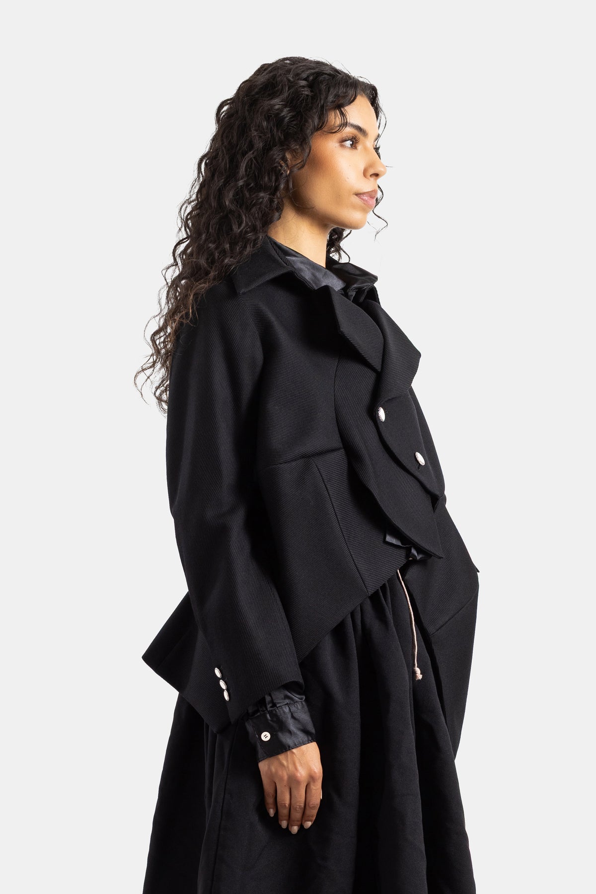 Chaqueta de lana negra Comme des Garçons de perfil con cuello acampanado, puños de satén y falda a juego