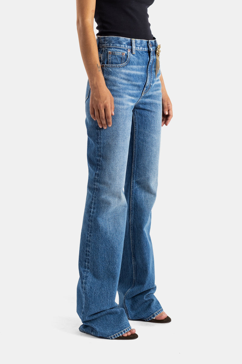 Chloé jean flare femme en denim bleu moyen vue latérale, silhouette évasée et détail chaîne dorée à la ceinture