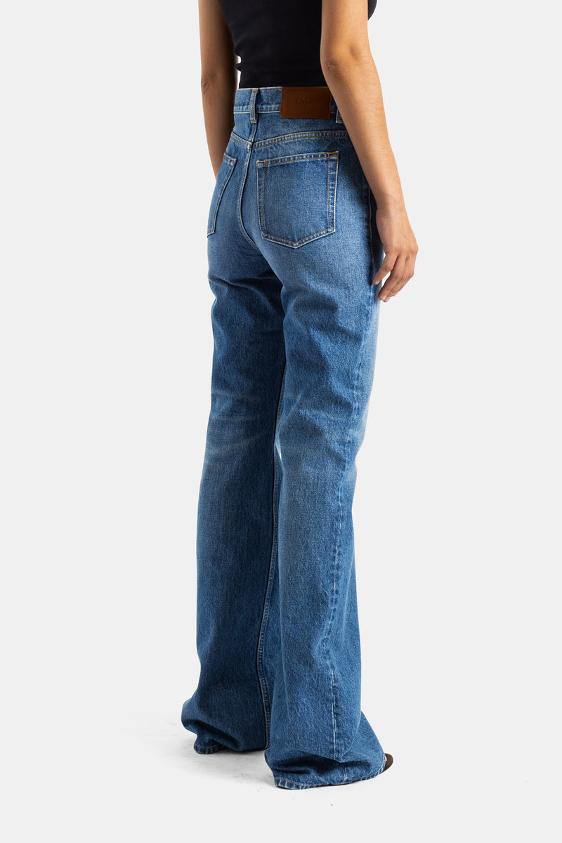 Chloé jean évasé bleu dos, poches arrière surpiquées et patch cuir cognac, coupe bootcut denim femme