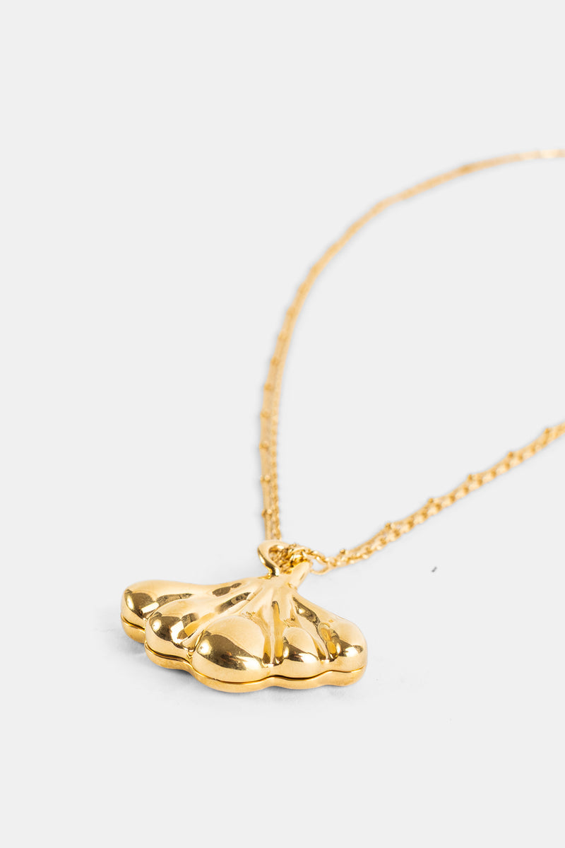 Chloé pendentif laiton doré forme ail sculptée, reflets brillants sur fond blanc, vue de côté rapprochée