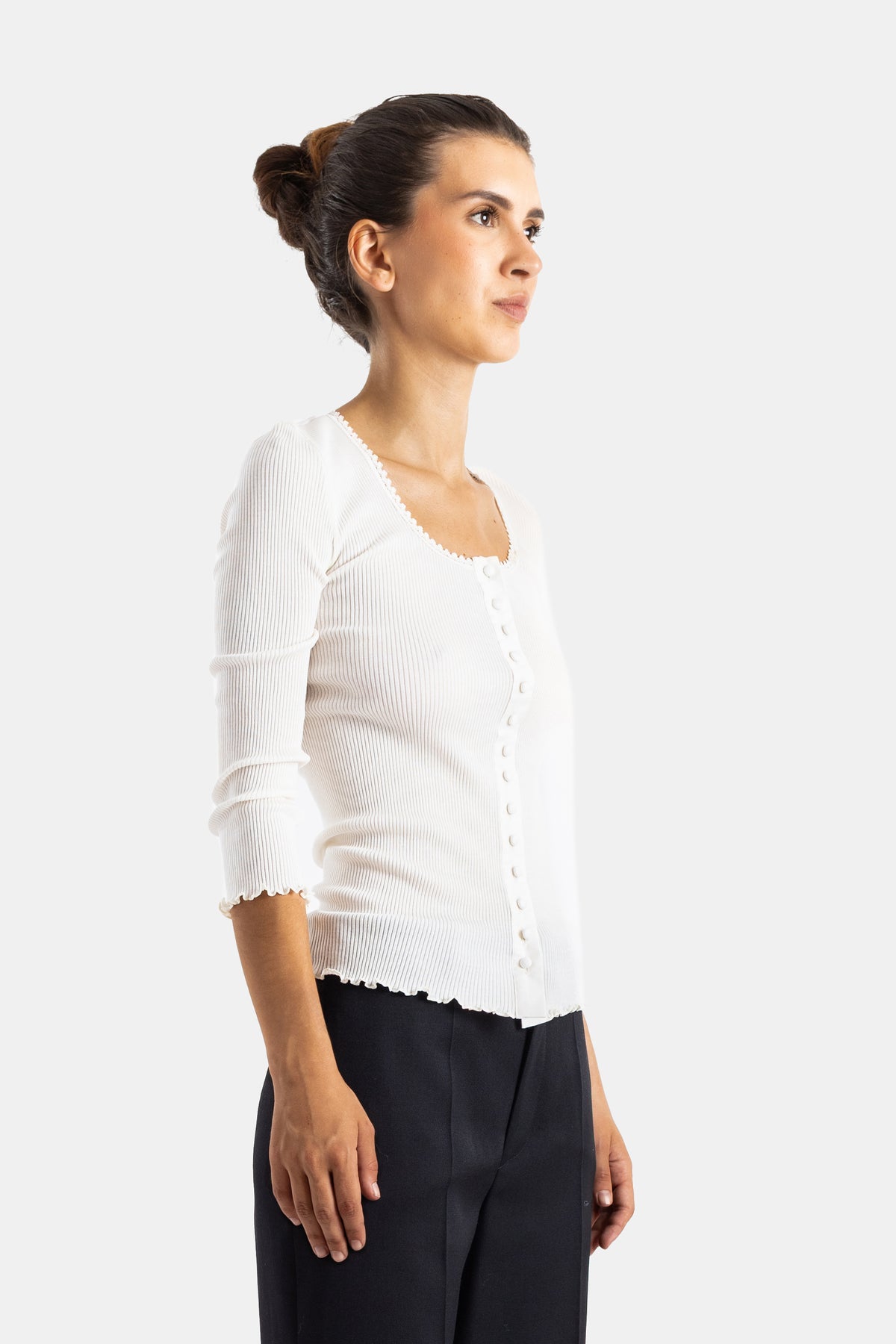 Chloé top côtelé blanc, vue de profil révélant les finitions ondulées aux poignets et à l'ourlet