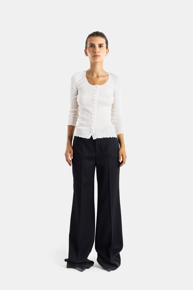 Chloé top en maille côtelée blanche porté avec un pantalon large noir, finitions festonnées visibles à l'encolure