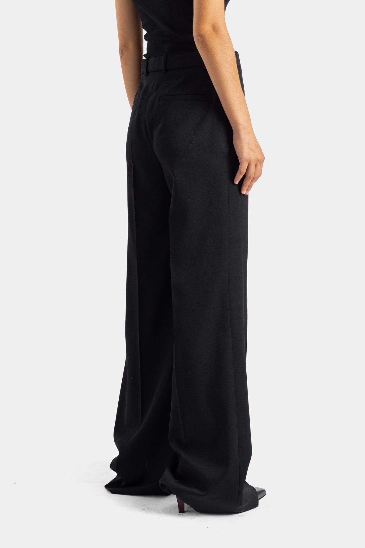 Chloé pantalon tailleur noir en laine, vue dos trois-quarts révélant la coupe évasée et la taille structurée