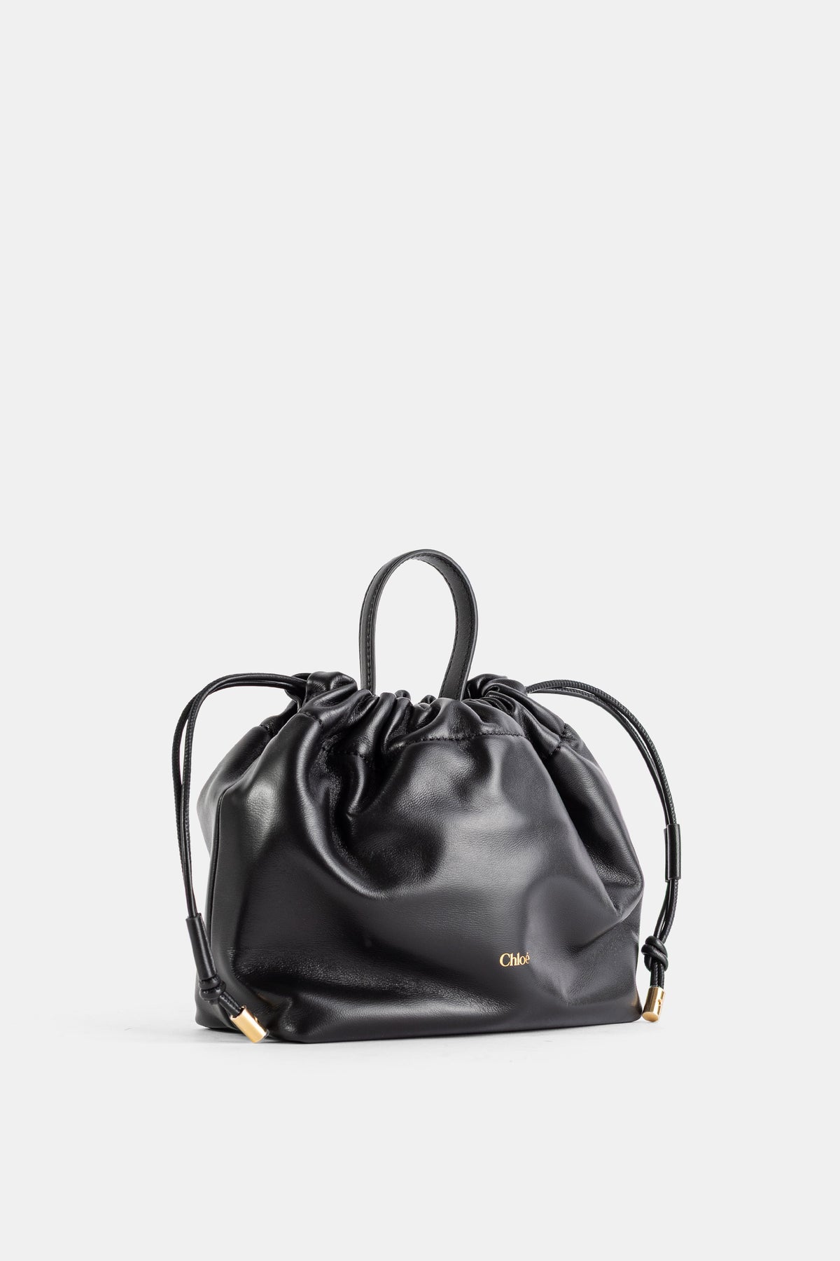 Sac Chloé Icons en cuir nappa noir, vue trois quarts avec logo doré et fermeture coulissante à nœud