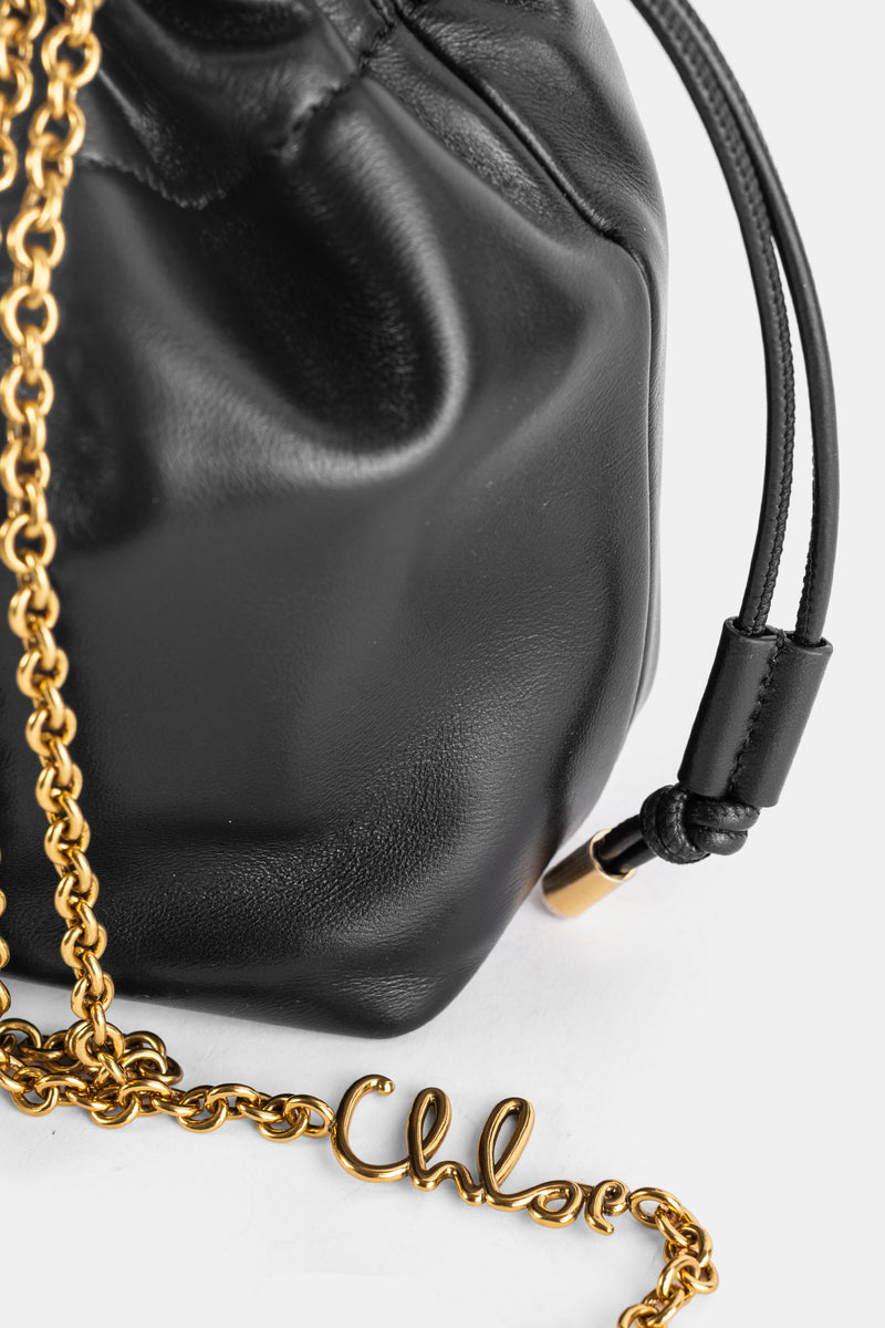 Détail quincaillerie Chloé Icons : logo scripty doré sur chaîne et nœud cuir noir de la cordelette coulissante