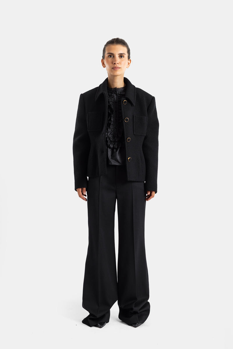 Chloé veste bouclette noire portée ouverte sur top froufrous texture jacquard poches cargo silhouette frontale femme