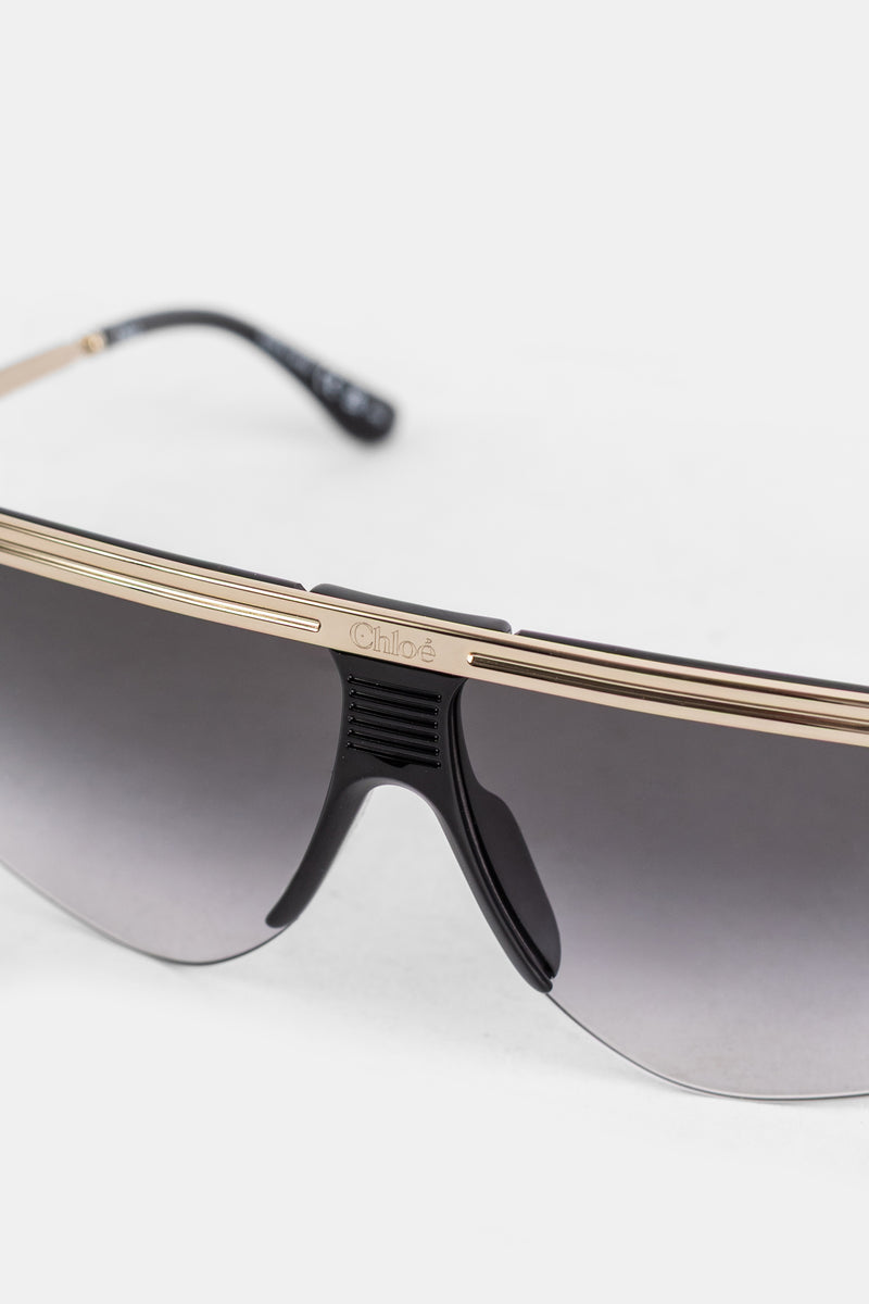 Gafas de máscara Chloé detalle de puente dorado logotipo grabado almohadilla negra y lentes grises degradadas