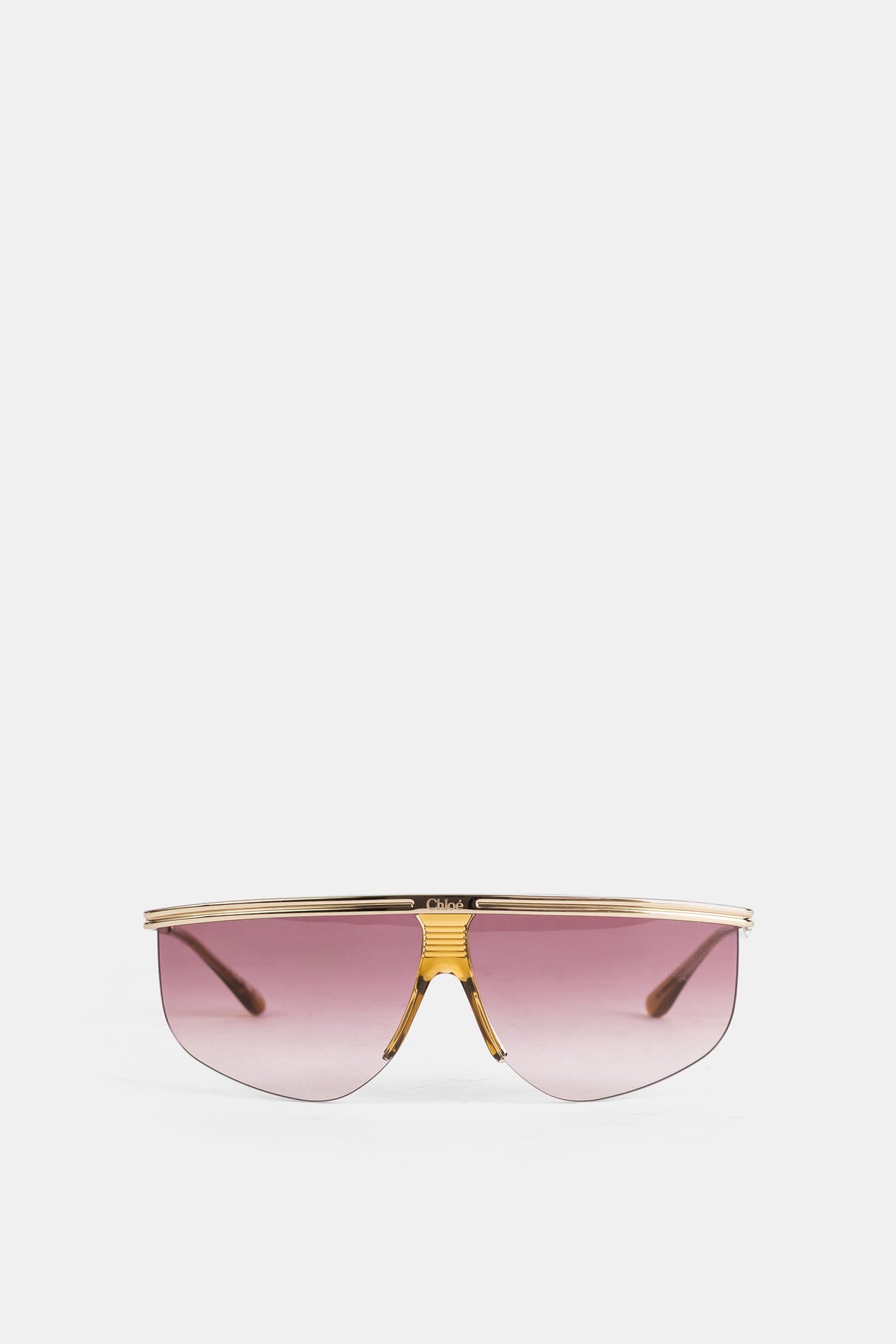 Gafas de sol de máscara Chloé para mujer con montura dorada y cristales rosa degradados de tipo escudo.