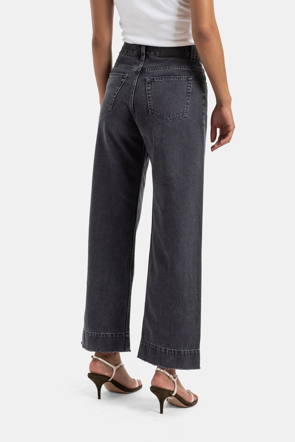 Jeans larghi donna Chloé vista posteriore con tasche in denim grigio lavato e sandali con listini bianchi