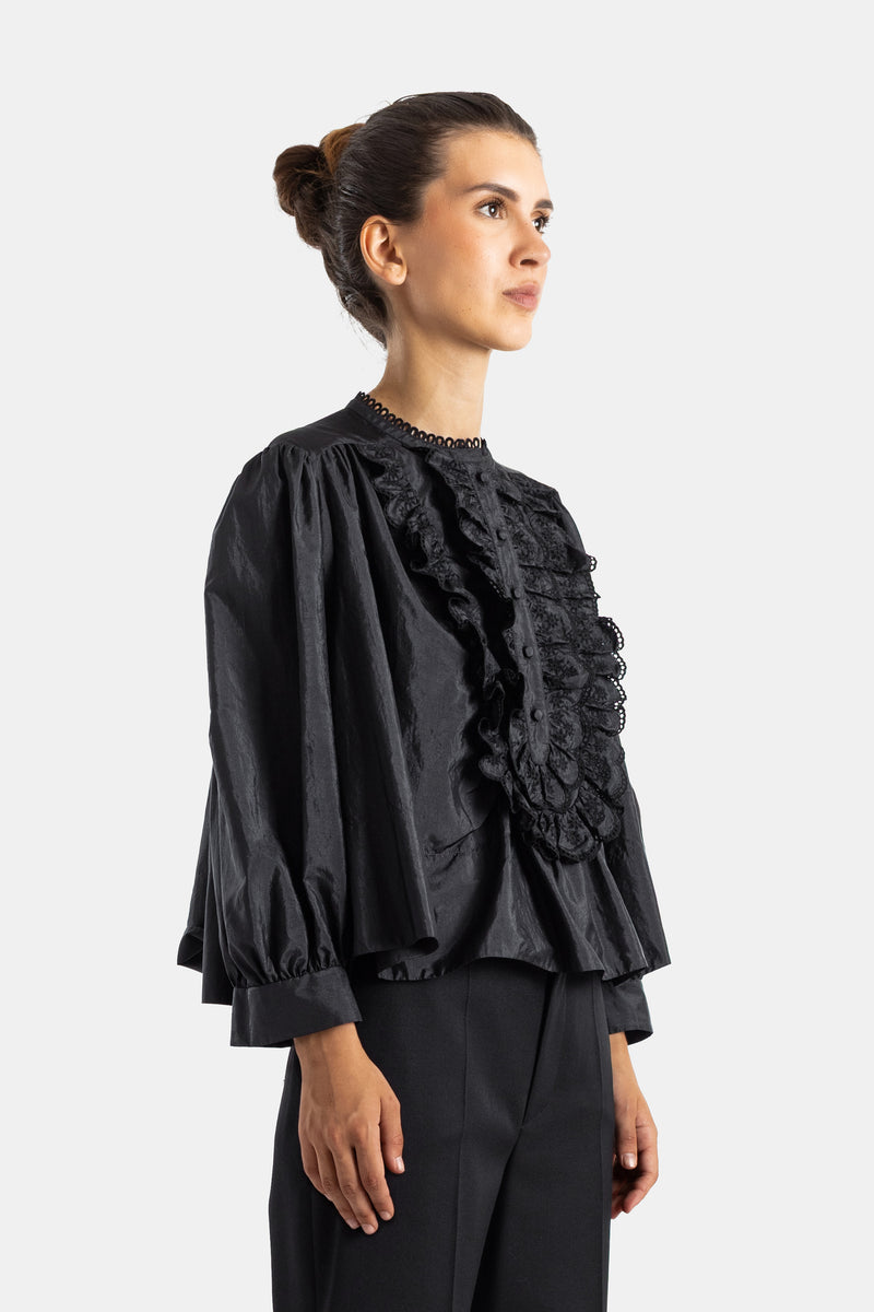 Chloé blouse en soie noire vue de profil, silhouette volumineuse avec manches bouffantes et broderies florales sur le devant