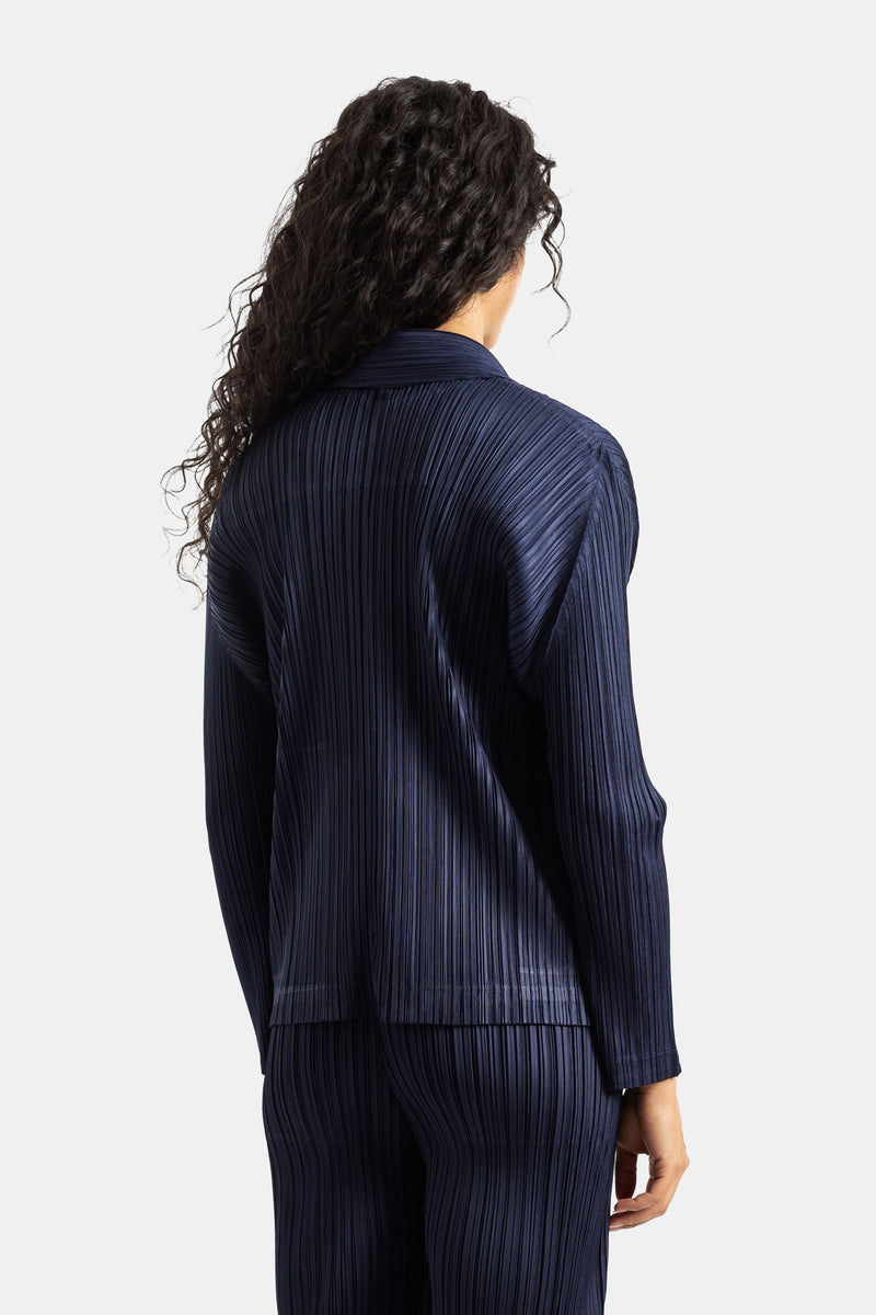 Rückansicht der plissierten Pleats Please Issey Miyake Jacke in Marineblau für Damen, eleganter Reverskragen.