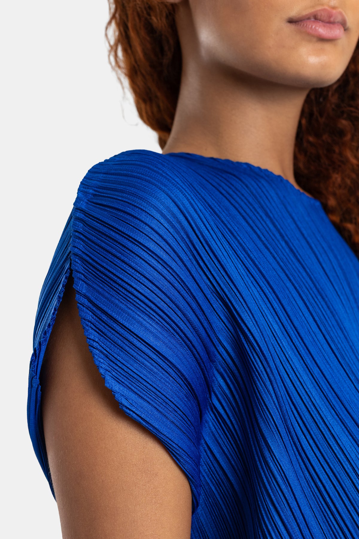 Pleats Please Issey Miyake top bleu roi détail épaule structurée tissu satiné micro-plissé reflets lumineux