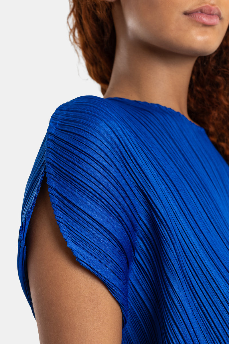 Pleats Please Issey Miyake top bleu roi détail épaule structurée tissu satiné micro-plissé reflets lumineux