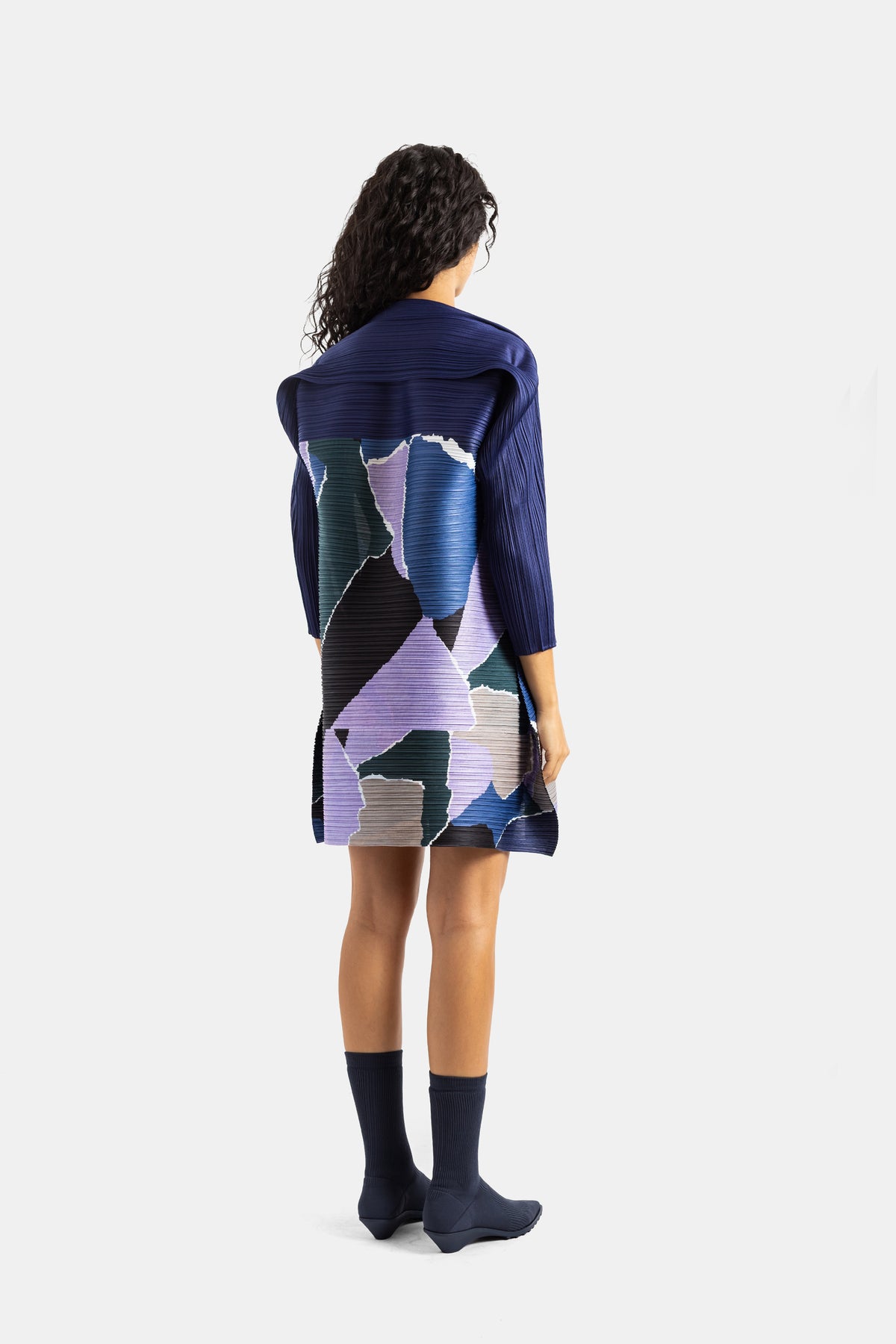 Pleats Please Issey Miyake korte jurk, geplisseerde rug met kleurrijke patchwork in blauw, paars, zwart en sjaalkraag.