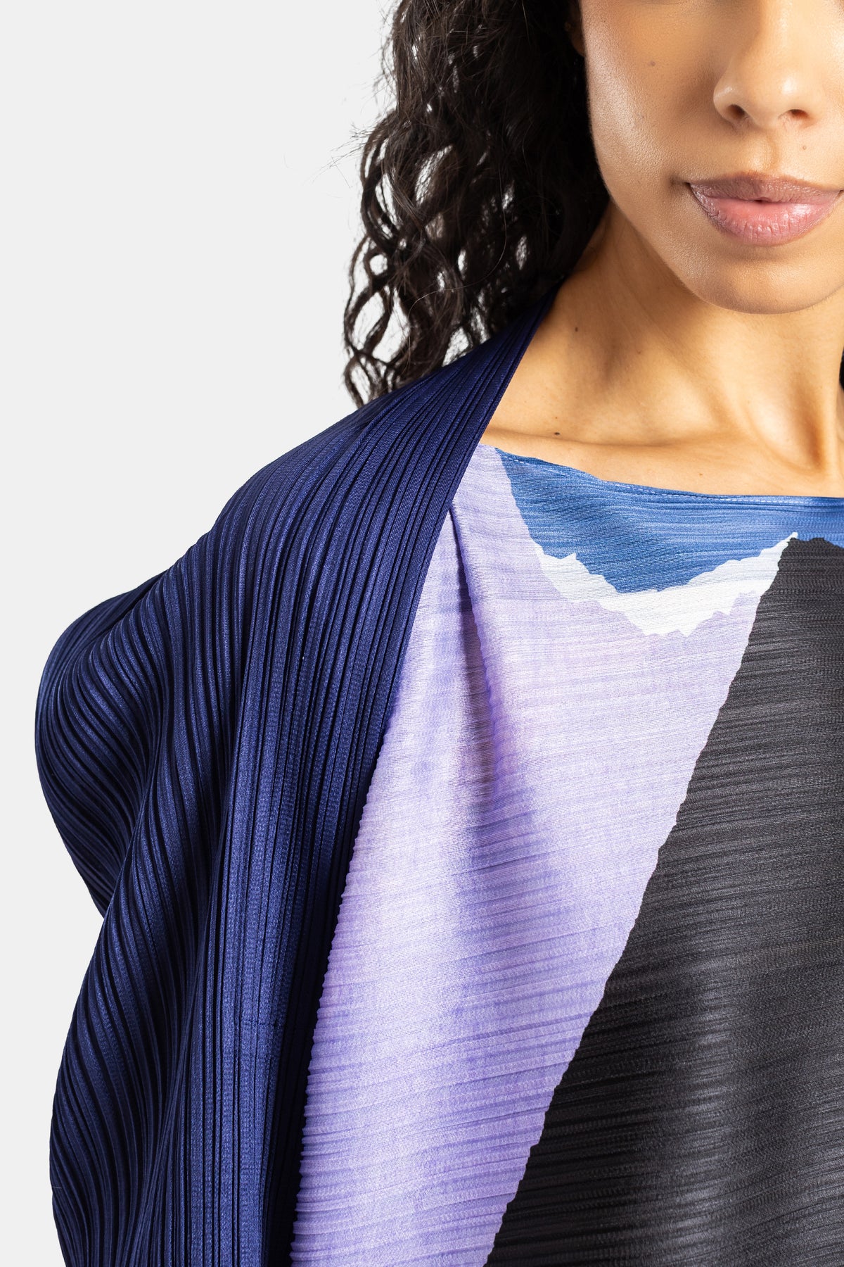 Pleats Please Issey Miyake geplisseerde jurk, zoom op halslijn met dégradé lila, zwart, blauw en wolkachtig motief.