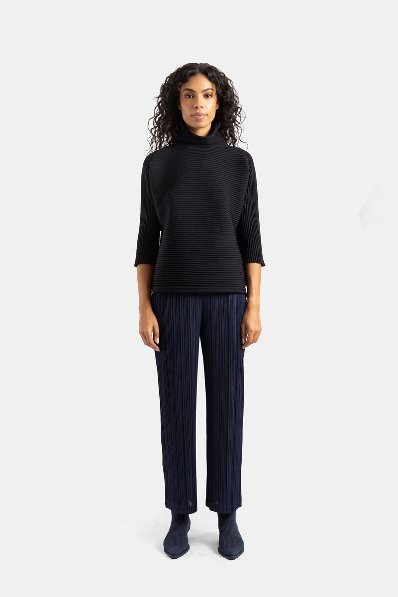 Top Pleats Please Issey Miyake de cuello alto negro con pantalón marino plisado para un conjunto coordinado de mujer