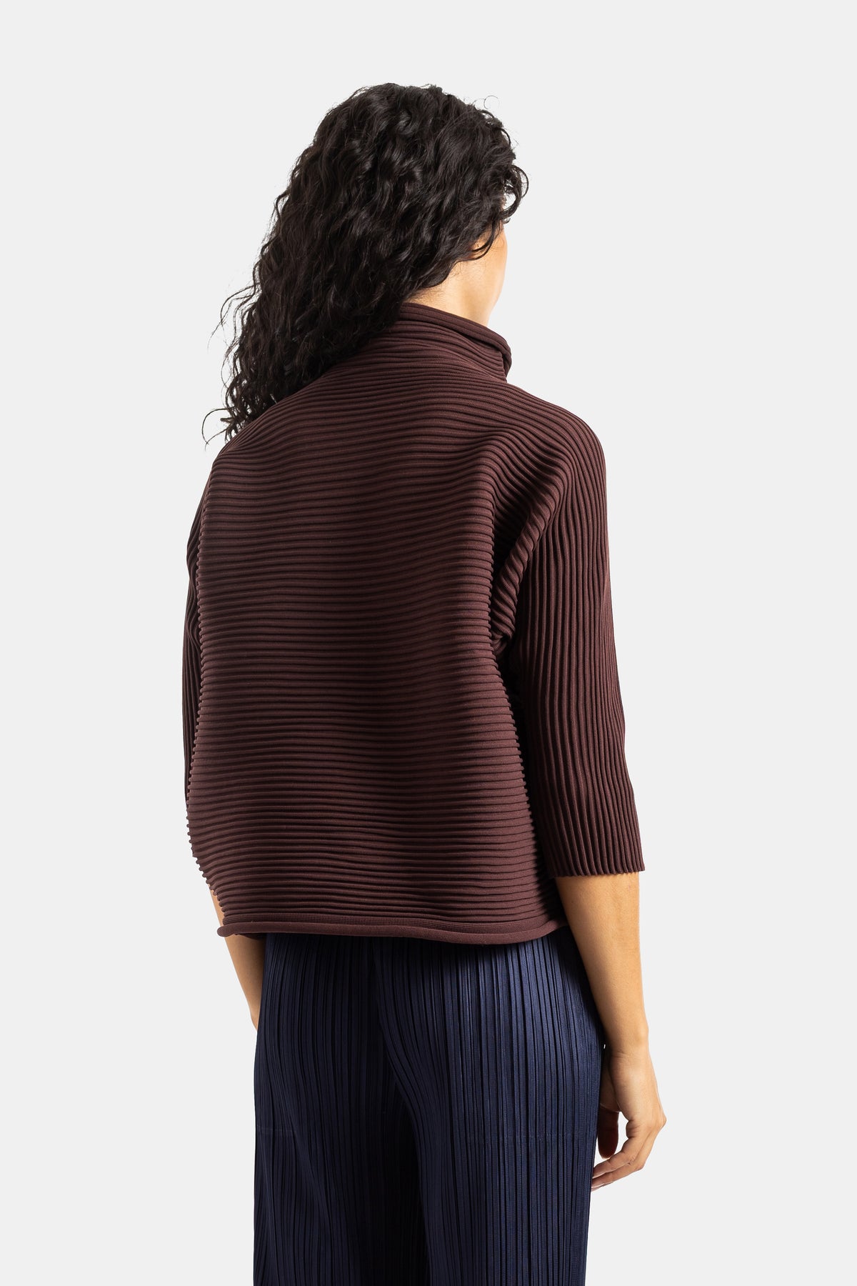 Top Pleats Please Issey Miyake de cuello alto marrón chocolate con textura acanalada, vista trasera de mujer