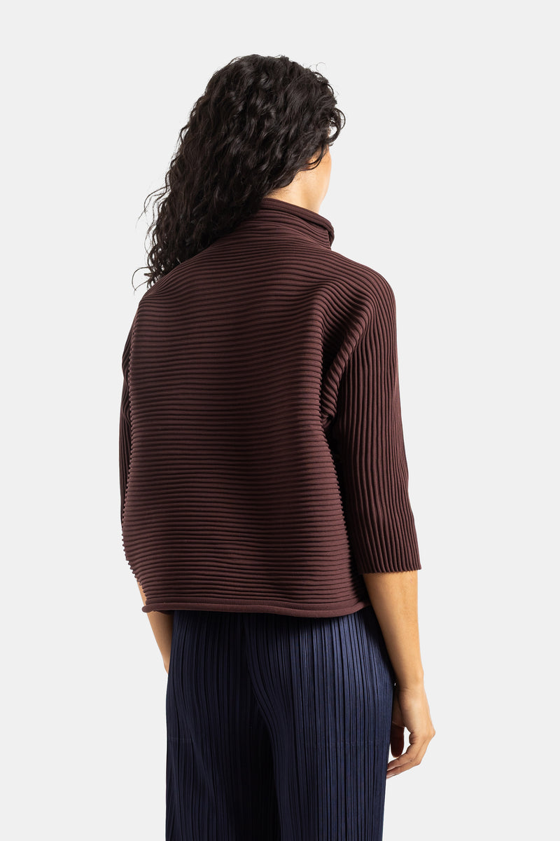 Top Pleats Please Issey Miyake de cuello alto marrón chocolate con textura acanalada, vista trasera de mujer