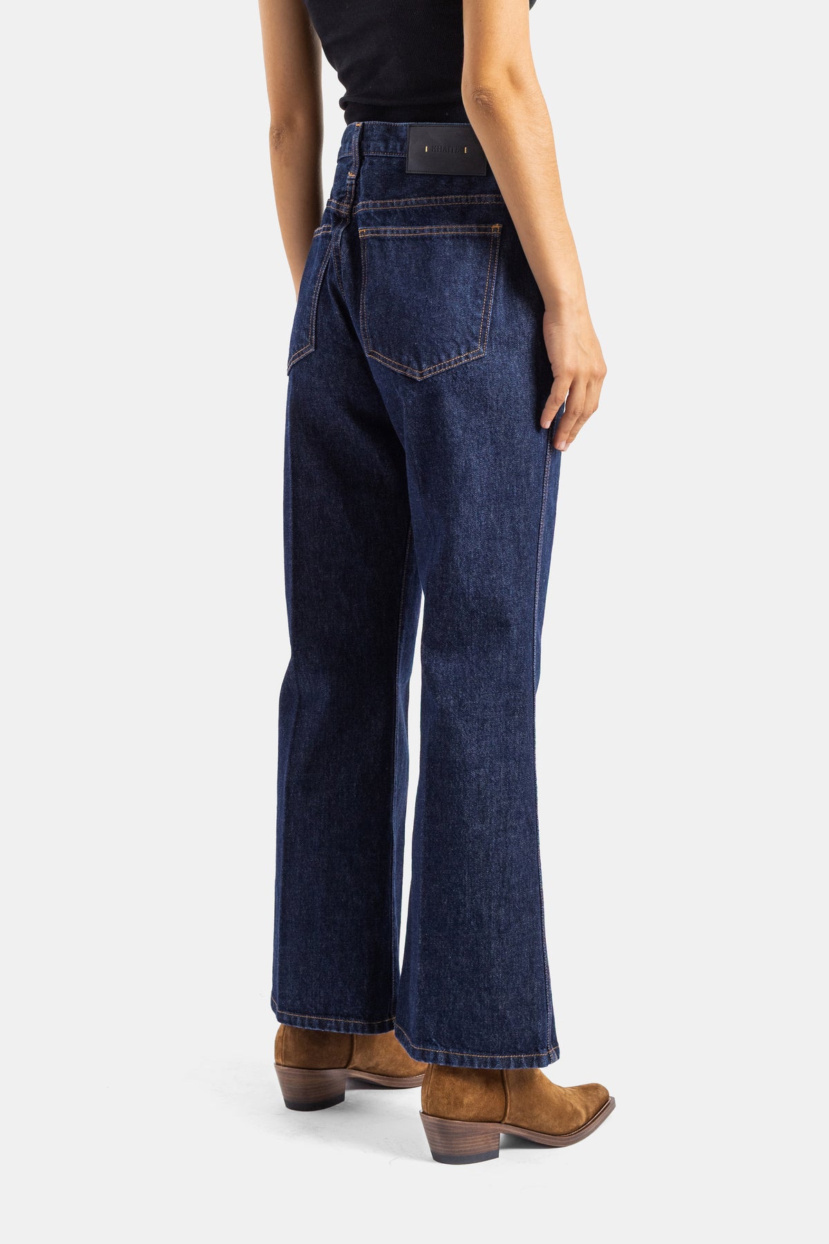 Khaite jean Clara dos vue trois quarts, poche arrière et étiquette noire sur denim brut bleu profond