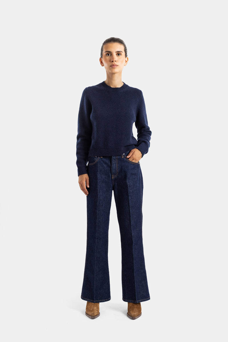 Khaite jean Clara évasé denim brut bleu marine porté avec pull cachemire assorti, silhouette complète