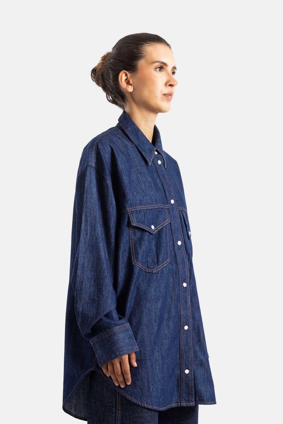 Khaite chemise denim oversize vue de profil, boutonnage pression blanc et coupe longue tombante
