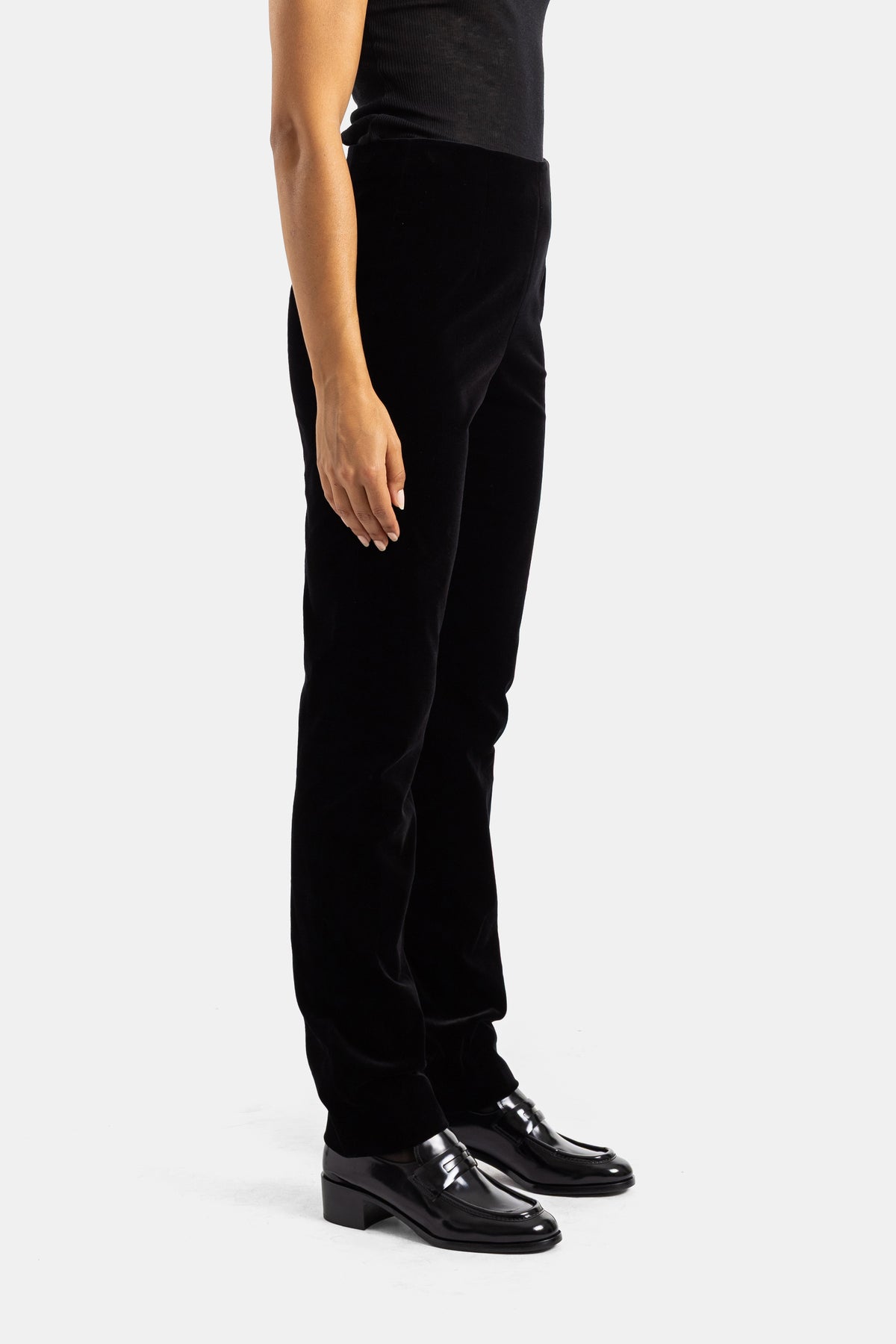 Calças de veludo preto Ryden da Khaite em vista de perfil, silhueta slim reta com mocassins de verniz