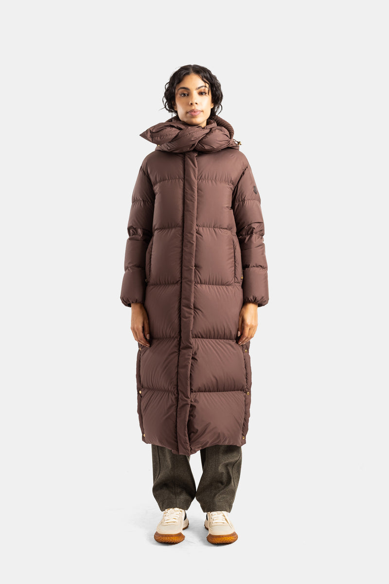 Cappotto lungo Moncler Ornement in piumino trapuntato marrone cioccolato con cappuccio annodato da donna.