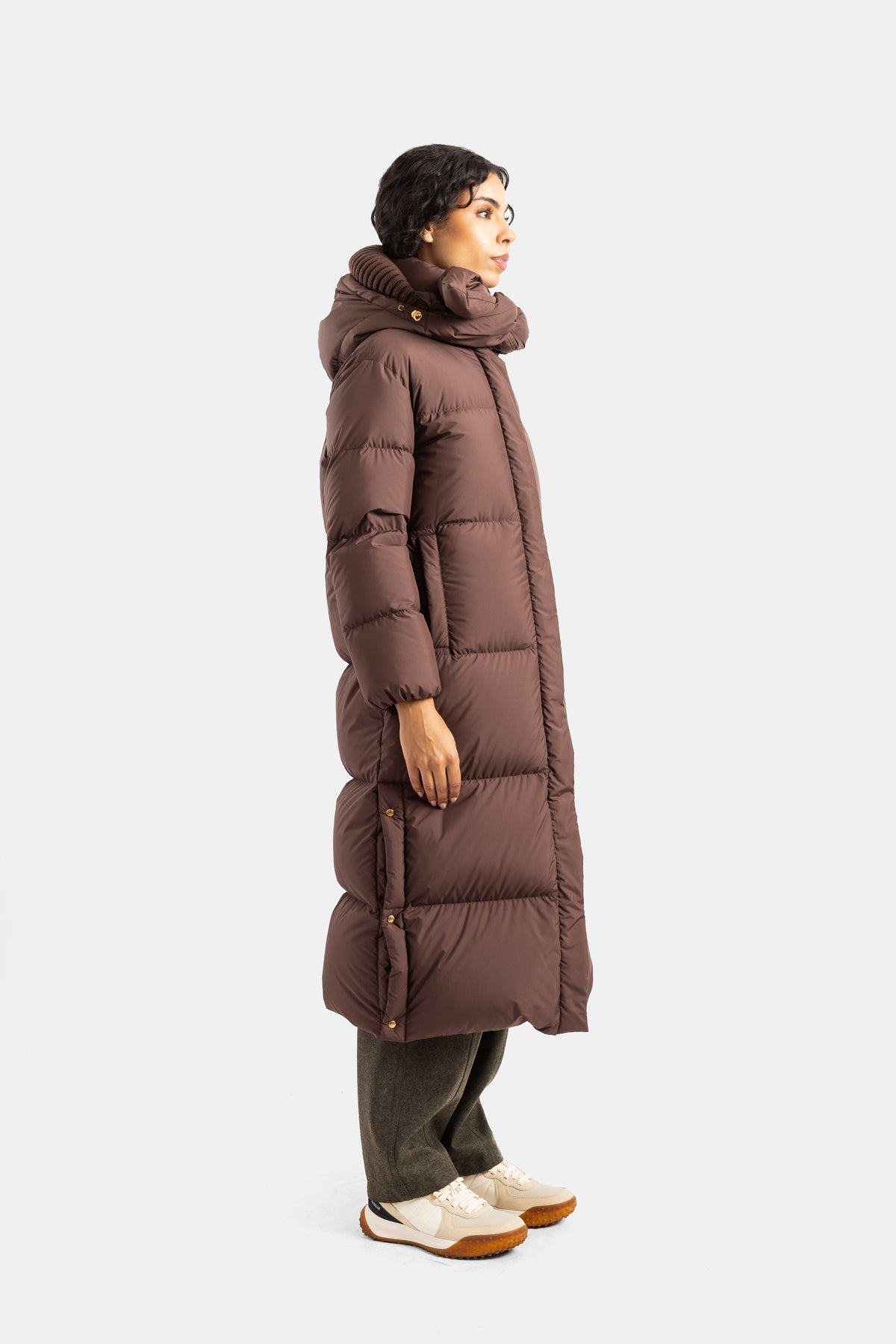 Plumífero largo de mujer Moncler Ornement de perfil con silueta recta oversize en marrón y zapatillas