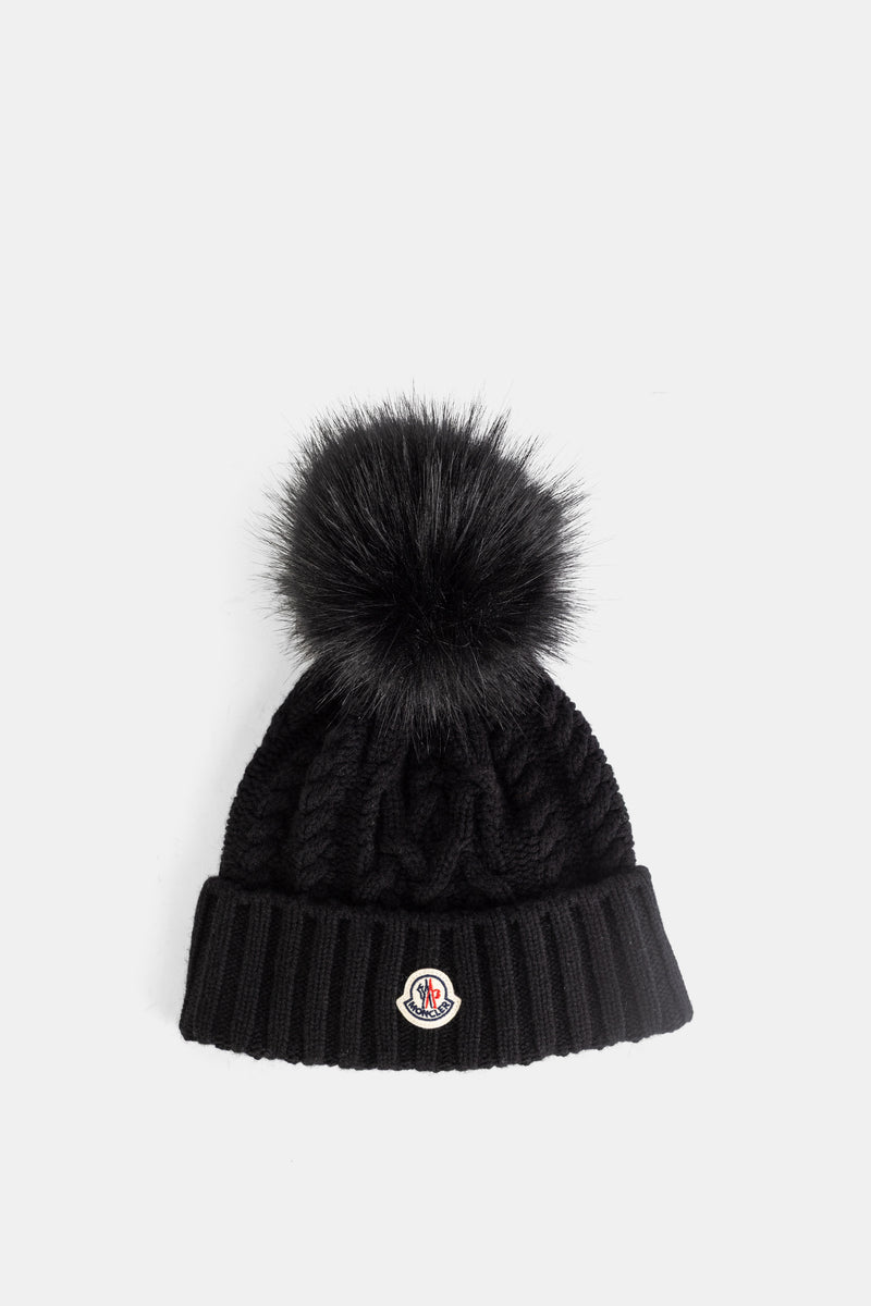 Moncler black cable-knit beanie designed in a dense wool knit with a real fur pompom and ribbed turn-up cuff.