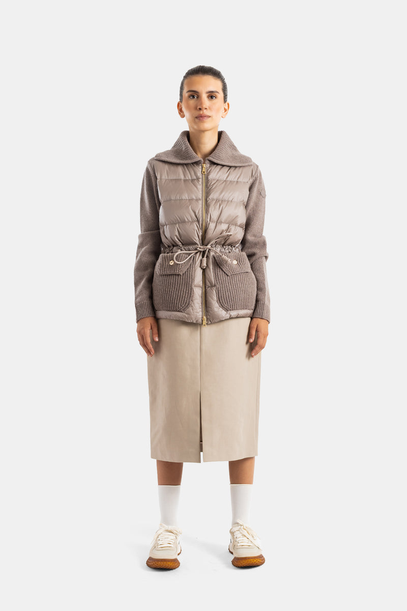 샌드 베이지 컬러의 Moncler 스트레이트 스커트. 포근한 토프 컬러 니트 패딩 재킷과 함께 우아하게 매치하여 세련되고 따뜻한 분위기를 완성하는 가을, 겨울 시즌의 매력적인 토탈 베이지 레이어드 스타일링.