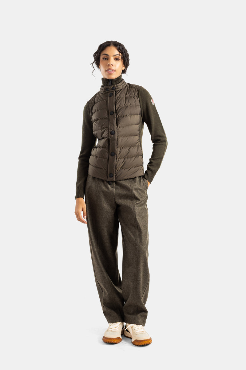 Gilet Moncler Grenoble kaki trapuntato su maglione in lana verde militare e pantaloni ampi da donna.