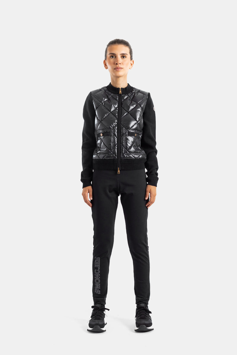 Moncler Damen-Luxus-Sportoutfit mit Jogginghose, Logo-Patch und schwarzer Steppjacke in der Gesamtansicht.