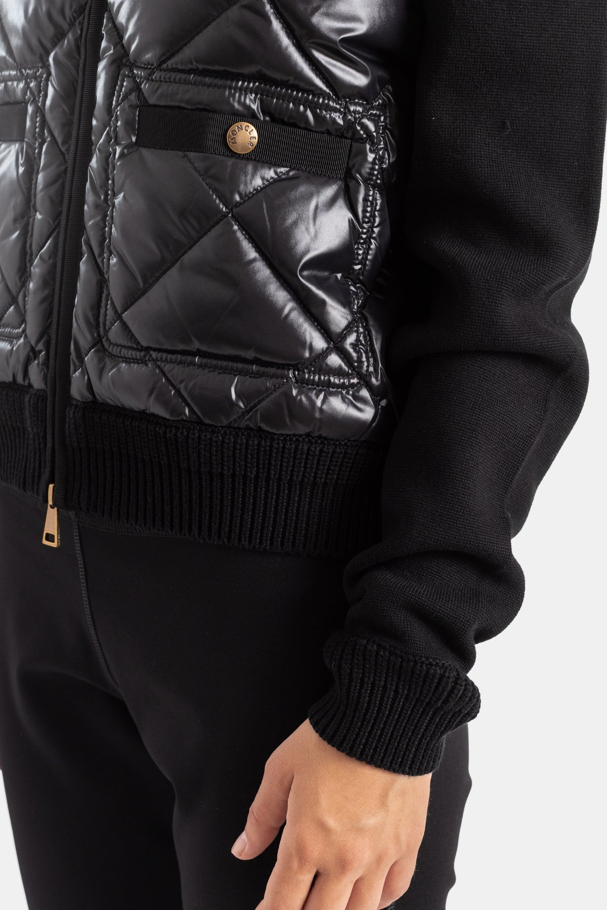 Detalle Moncler bolsillo con cremallera dorada bajo de canalé de punto chaqueta acolchada nailon negro mujer