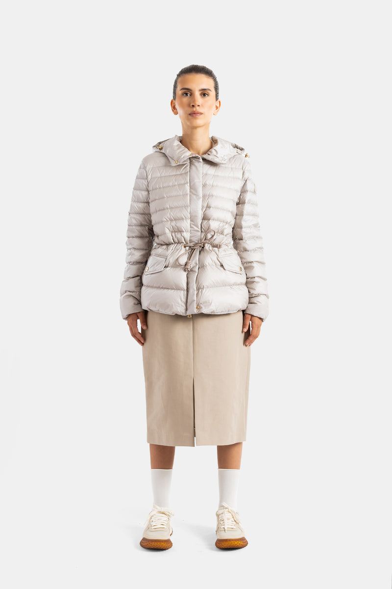Moncler women's down jacket, front view, drawstring waist, gold cords, beige midi skirt, white sneakers